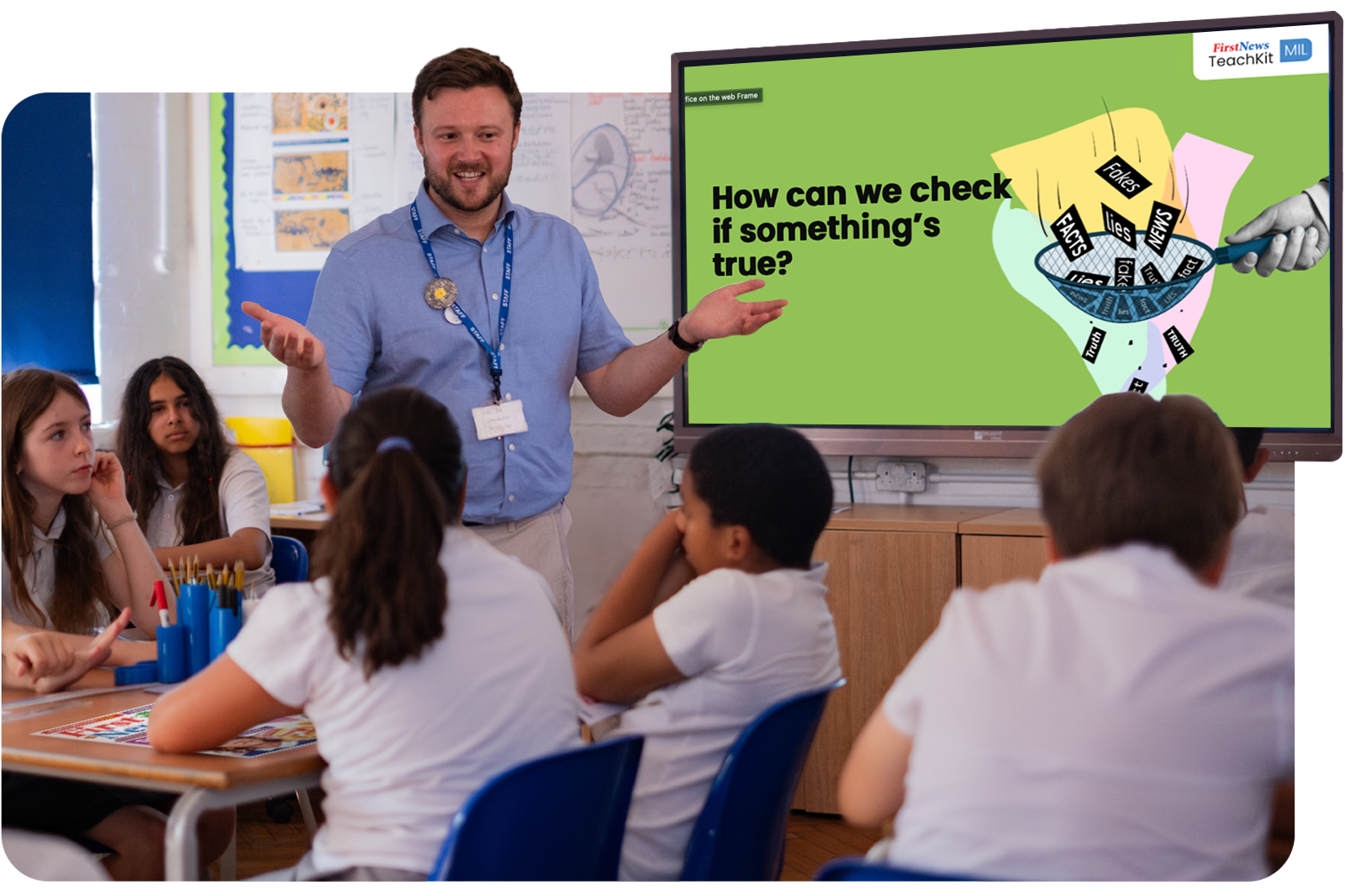 A teacher leading a classroom discussion with a First News TeachKit lesson on the screen