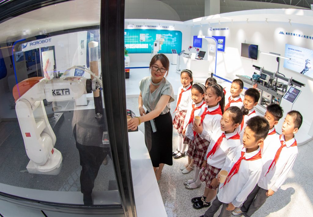 Elementary school students see an intelligent coffee robot at an exhibition in China, in July 2022 (CFOTO/Future Publishing via Getty Images).