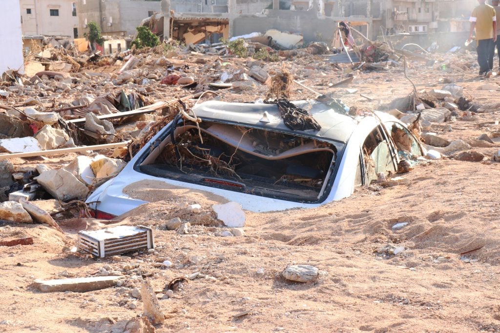 DERNA, LIBYA - SEPTEMBER 12: A damaged vehicle is stuck debris after the floods caused by the Storm Daniel ravaged disaster zones in Derna, Libya on September 12, 2023. The death toll from devastating floods in Libya's eastern city of Derna has risen to 5,300 and thousands of people are still missing, the country's official news agency reported on Tuesday. (Photo by Abdullah Mohammed Bonja/Anadolu Agency via Getty Images)