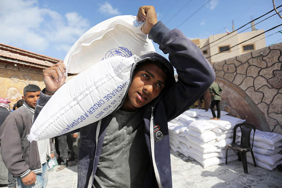 A civilian in Gaza collects flour sent in by the United Nations